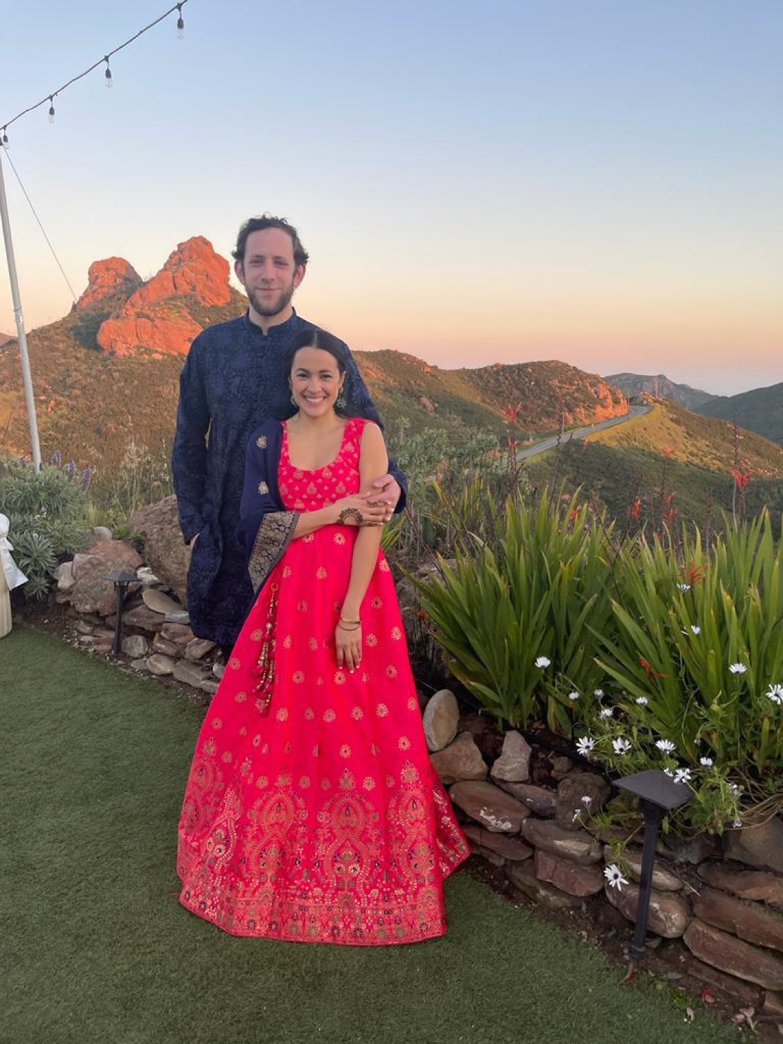 Salma and Eric dressed for a wedding in Malibu at sunset