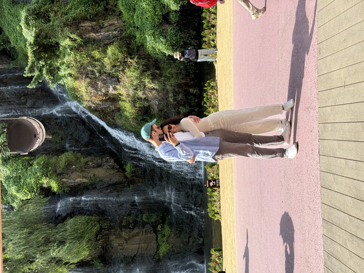 Salma and Eric in front of a waterfall in Seoul
